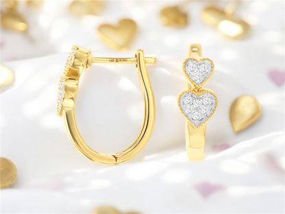 A close-up of Royal Jewelry's exquisite 14k YG diamond heart hoops, displayed against a delicate heart-themed backdrop with golden and pink accents. Expertly designed for aficionados of YG jewelry.