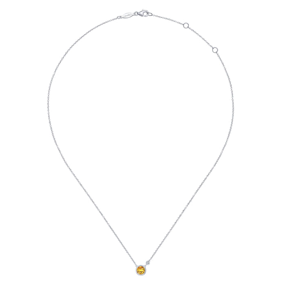 Introducing the Gabriel & Co 925 Sterling Silver Citrine and Diamond Pendant Necklace. This delicate piece features a small, round citrine gemstone, elegantly set in a minimalistic design. The thin sterling silver chain, which has a convenient clasp at the top, perfectly complements the sophisticated charm of this necklace.