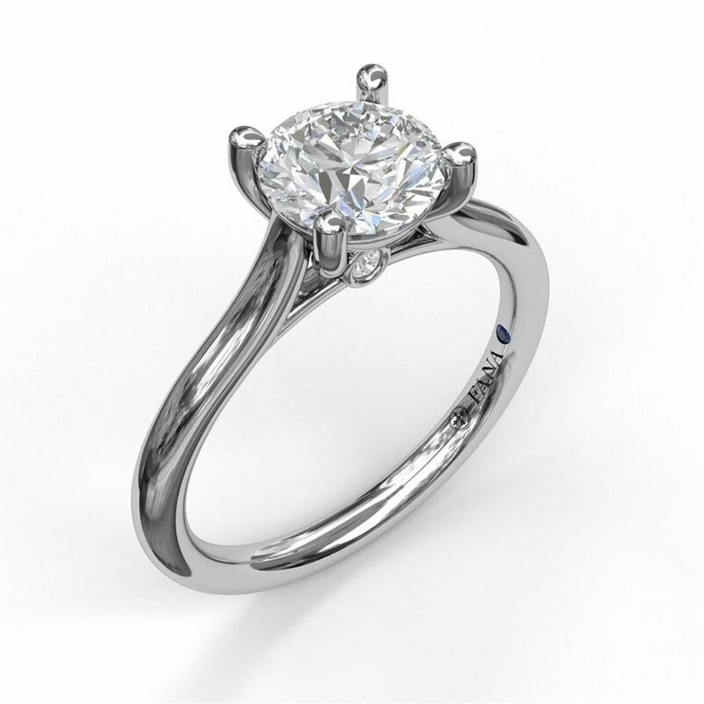 A close-up of the FANA 14K White Gold Round Solitaire With Cathedral Band Engagement Ring featuring a large, round, brilliant-cut diamond as the centerpiece. The ring has four prongs securing the conflict-free diamond and a smooth, polished band. A small detail, possibly a maker's mark, is visible on the inner side of the band.