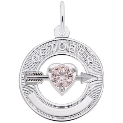 A circular silver pendant, the "October Love Birthstone Charm / Sterling Silver," features the word "OCTOBER" engraved around the top. Inside, an arrow pierces a pink, heart-shaped gemstone, symbolizing October's birthstone. The Rembrandt Charms piece includes a small loop at the top for easy attachment to a chain.