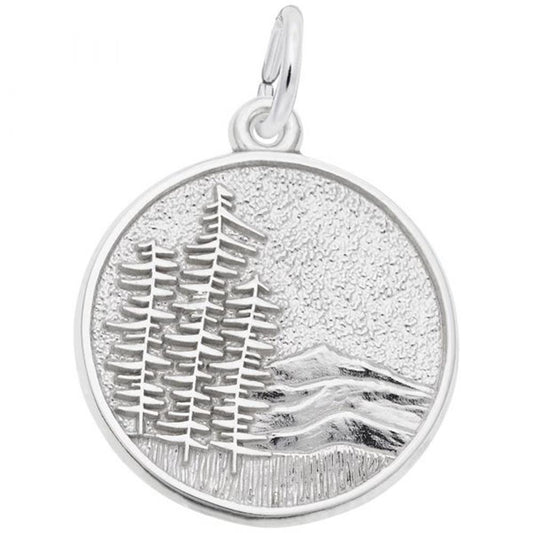 The Rembrandt Charms Mountain Scene Charm in sterling silver boasts a circular pendant with an embossed design featuring three pine trees and a mountainous landscape in the background. This elegant charm includes a small loop at the top for easy attachment to a chain or bracelet.