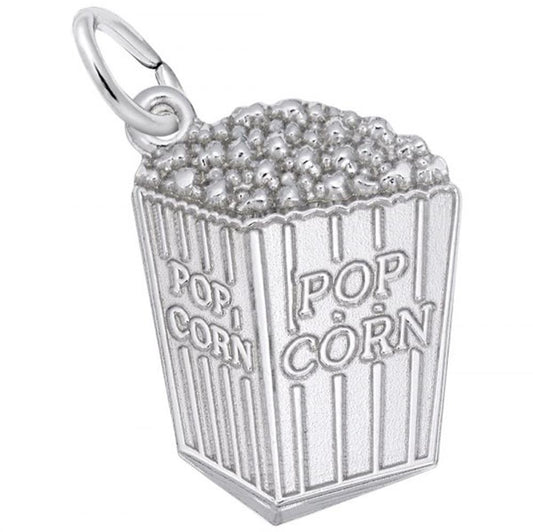 The Rembrandt Charms Popcorn Charm / Sterling Silver is intricately crafted in the shape of a popcorn box, complete with individual popcorn kernels at the top and vertical stripes on the sides. The front of this charming piece features the word "POPCORN" in raised text and has a loop at the top for easy attachment to a chain or bracelet.