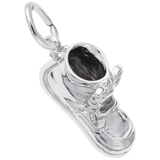 The image shows the Sterling Silver Baby Shoe with Laces Charm from Rembrandt Charms. The charm is crafted in sterling silver and depicts a detailed baby shoe with laces. It measures 0.62 inches by 0.28 inches (15.84 mm x 8.5 mm) and has the style number 8222. This charm is a perfect keepsake for new parents and grandparents, symbolizing the joy of early childhood.