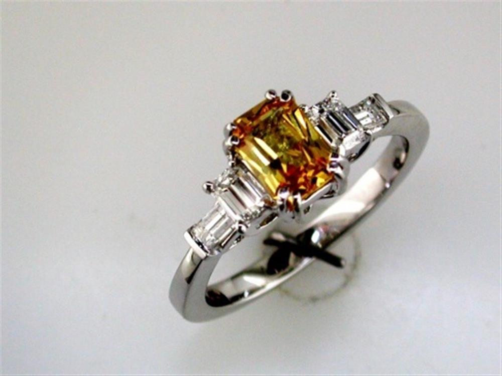 The Royal Jewelry 14k WG Yellow Sapphire and Diamond Ring, size 6.75, showcases a central yellow sapphire with two clear diamond baguette-cut stones on each side, set against a white background.