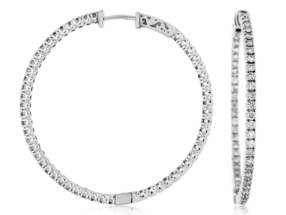 The 14k WG 41mm diamond hoops from Royal Jewelry showcase two silver hoops encrusted with small, sparkling stones that shimmer effortlessly. Crafted in 14k white gold, these earrings are displayed from both the front and side view to highlight their circular shape and intricate design.