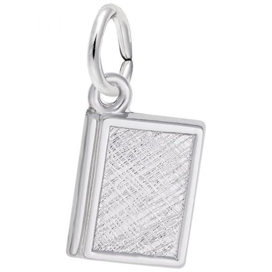 This luxurious accessory is the Book Charm in Sterling Silver by Rembrandt Charms, resembling a small textured book with a polished finish. The pendant includes a loop at the top for attaching to a chain or bracelet, and the front cover features an elegant crisscross pattern.