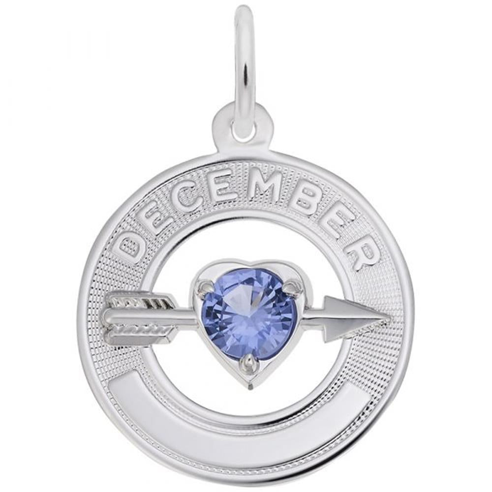 The December Love Birthstone Charm by Rembrandt Charms is a sterling silver circular pendant with "DECEMBER" engraved at the top. It features a heart-shaped blue topaz gemstone at the center, representing December's birthstone, with an arrow through it. The pendant has a small loop at the top for attaching to a chain.