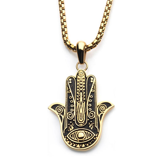 An ornate INOX Gold Plated Hamsa Pendant hangs from a bold gold-plated box chain. The men's pendant features intricate patterns centered around an eye symbol, set against a striking black background. The design is symmetrical, with distinct detailing on each finger of the hand-shaped pendant.