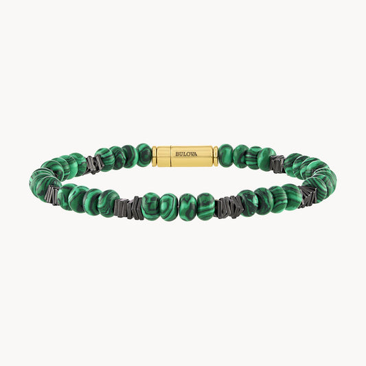 Product Data-Informed Rewrite: Presenting the Malachite Magnetic Bracelet by Bulova Watch Company. This luxurious bracelet features round green malachite beads interspersed with small black spacers. It is adorned with a gold-plated sterling silver cylindrical clasp, elegantly engraved with "Bulova." The marbled pattern of the beads creates a striking visual effect, showcasing the renowned craftsmanship of Bulova.