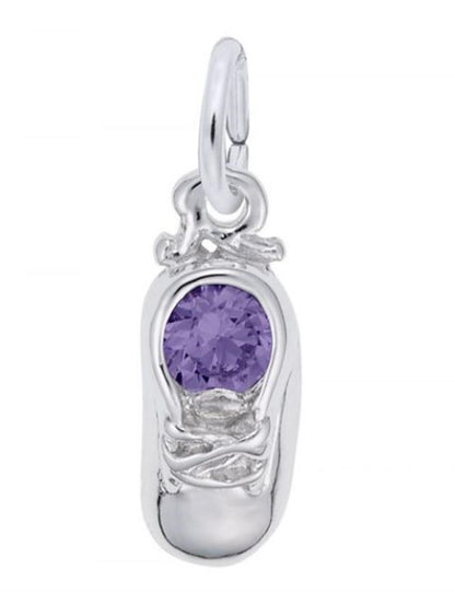 The image shows the Sterling Silver February Baby Shoe Charm from Rembrandt Charms. The charm is crafted in sterling silver and features a detailed baby shoe with an amethyst-colored stone. It measures 0.2 inches by 0.43 inches (5 mm x 11 mm) and has the style number 2734-002. This charm is a perfect keepsake for commemorating the birth of a February baby.