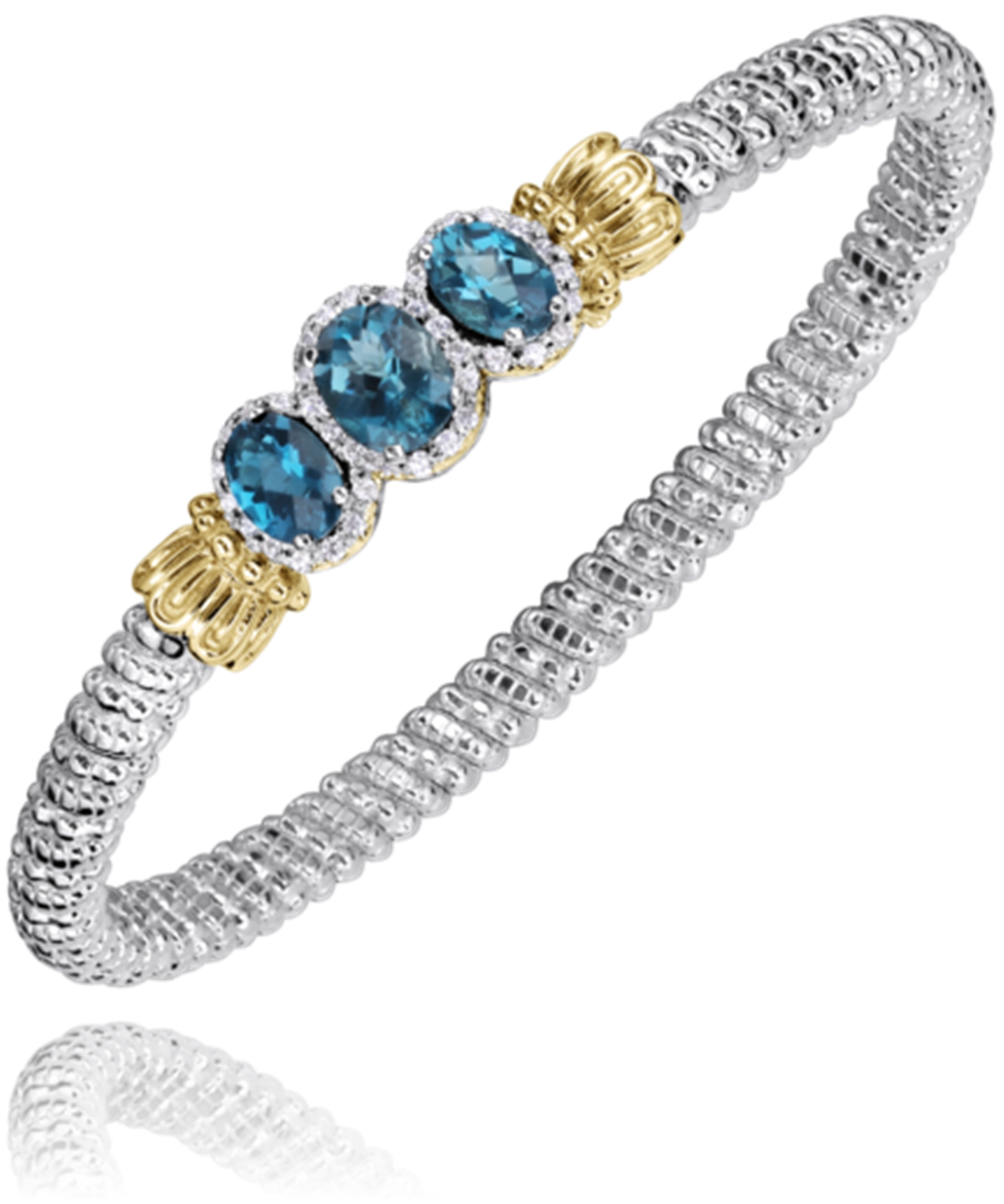 The Alwand Vahan Jewelry bracelet, named 4MM LONDON BLUE, showcases a silver braided design adorned with three London Blue gemstones. Each stone is elegantly framed by small diamonds set in a gold bezel, creating a flexible and textured piece that embodies elegance and sophistication.