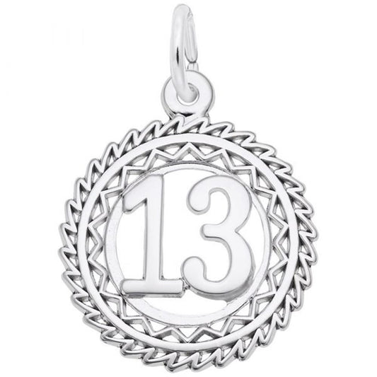 The Rembrandt Charms Number 13 Charm is crafted from sterling silver and features the number 13 in the center, surrounded by an intricate zigzagged border. The symmetrical design includes a loop at the top for easy attachment to a necklace or bracelet, and is polished to give it a shiny, reflective finish.