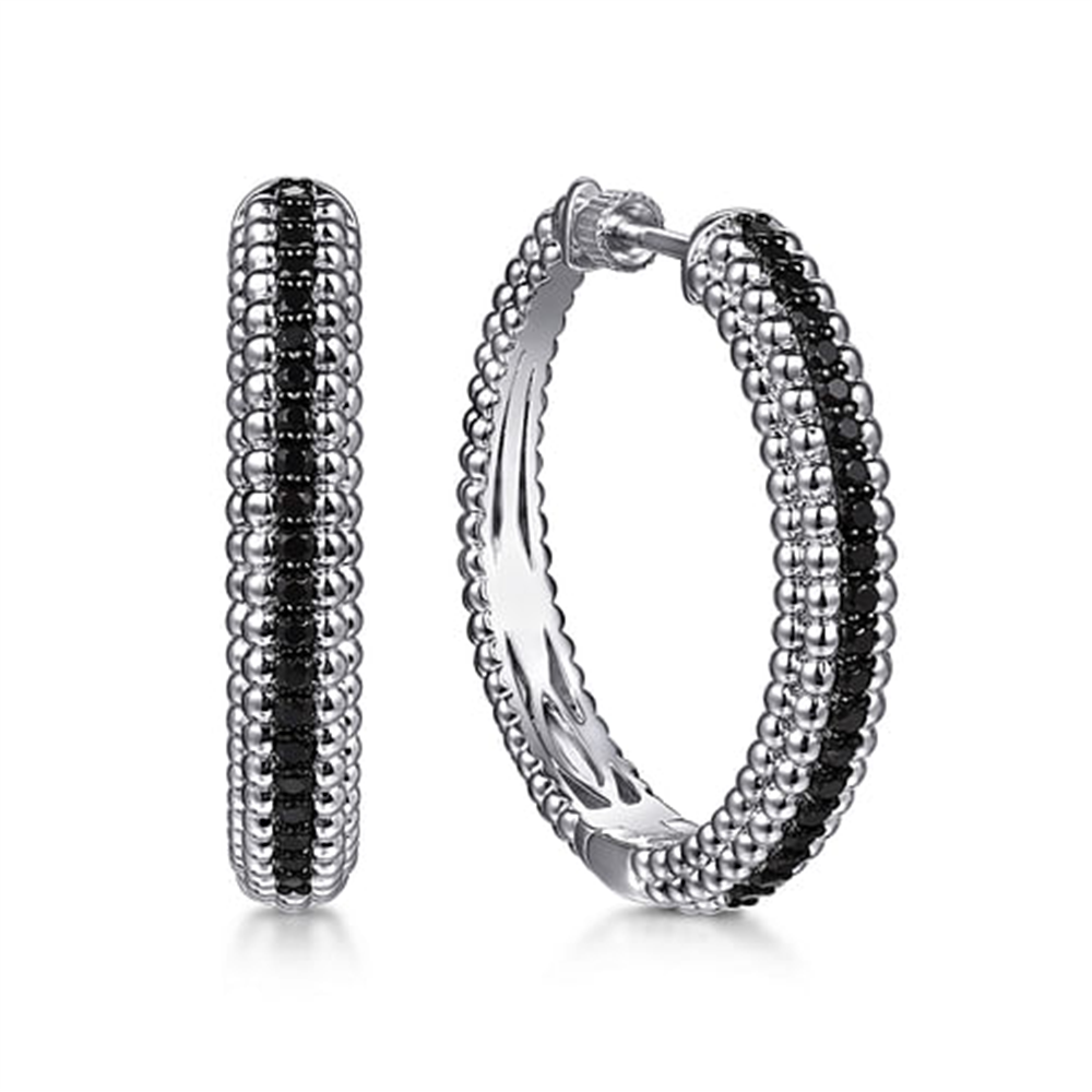 Gabriel & Co's 925 Sterling Silver Bujukan Black Spinel classic hoop earrings feature a textured, beaded exterior with a row of small black spinel stones, offering a sophisticated and elegant look. They are displayed with one earring facing forward and the other in profile.