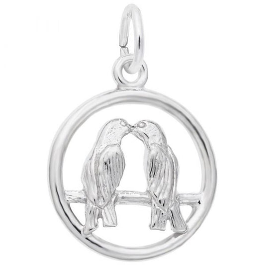 The Love Birds Charm by Rembrandt Charms, crafted from sterling silver, showcases two love birds perched on a branch with their beaks touching, framed within a circle to create a symmetrical and romantic design.