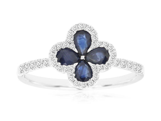 The Royal Jewelry 14k WG Sapphire and Diamond ring in size 7 features a captivating floral cluster with four teardrop-shaped sapphire gemstones. Each sapphire is elegantly outlined by small, clear stones, creating a sparkling design that rivals the brilliance of a diamond ring.