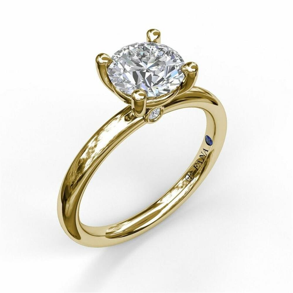 The 14K Yellow Gold Classic Round Cut Solitaire Engagement Ring by FANA features a large, round-cut conflict-free diamond held in a minimalist four-prong setting. The smooth, polished band also has a small gemstone embedded discreetly on the inner side.