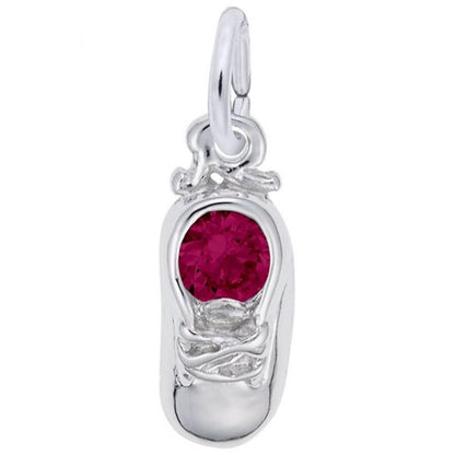 The image shows the Sterling Silver July Baby Shoe Charm from Rembrandt Charms. The charm is crafted in sterling silver and features a detailed baby shoe with a ruby-colored stone. It measures 0.2 inches by 0.43 inches (5 mm x 11 mm) and has the style number 2734-007. This charm is a perfect keepsake for commemorating the birth of a July baby.