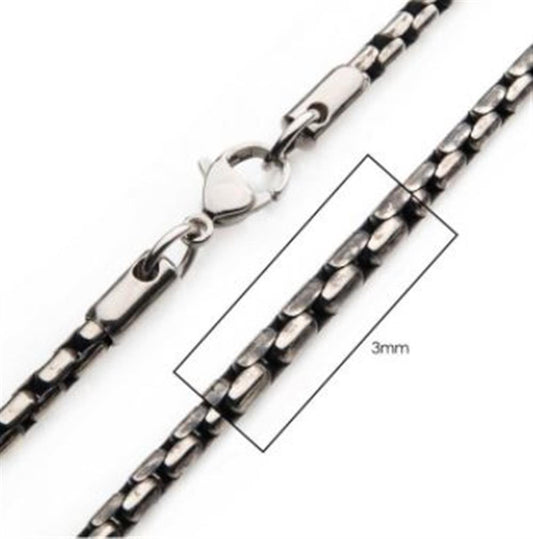 A close-up image of the 3mm Oxidized Steel Boston Link Chain from INOX, featuring a stainless steel chain with a lobster clasp. The meticulously detailed rectangular links are each 3mm wide. The clasp is attached to one end, while the loop for fastening is visible at the other end. The chain measures 24 inches in length.