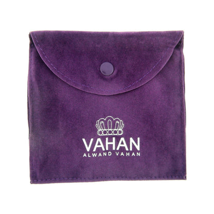 A small, square purple velvet pouch with a snap button closure at the top. The pouch is stamped with the "Alwand Vahan Jewelry" logo, featuring a crown-like emblem above the brand name. Perfect for holding an Essential Diamonds 8mm Vahan bracelet adorned with genuine diamonds and 14k yellow gold accents.