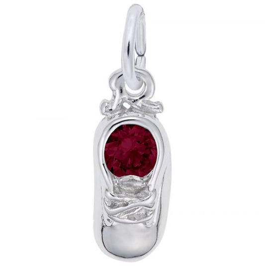 The Jan Baby Shoe Sterling Silver Charm from Rembrandt Charms is a beautifully crafted pendant shaped like a small sneaker, adorned with a red gemstone at its center where the laces would be. This polished charm features a convenient loop at the top for easy attachment to any chain or bracelet.