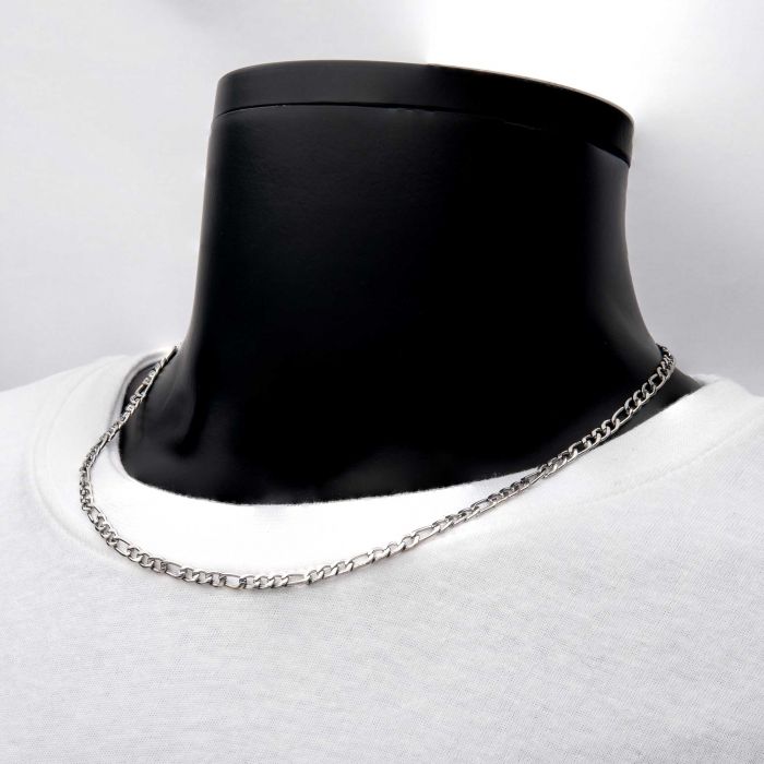 The 4mm Steel Figaro Chain by INOX, measuring 20 inches, is elegantly displayed on a black mannequin bust against a light background. The mannequin, dressed in a plain white t-shirt, highlights the simplicity and elegance of this men's necklace.