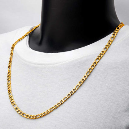 A 6mm 18K Gold Plated Figaro Chain from INOX, featuring a refined and timeless design, is displayed on a black mannequin wearing a white shirt. The men's stainless steel necklace drapes naturally around the neck, highlighting its sleek and polished appearance against the contrasting white-and-black background.