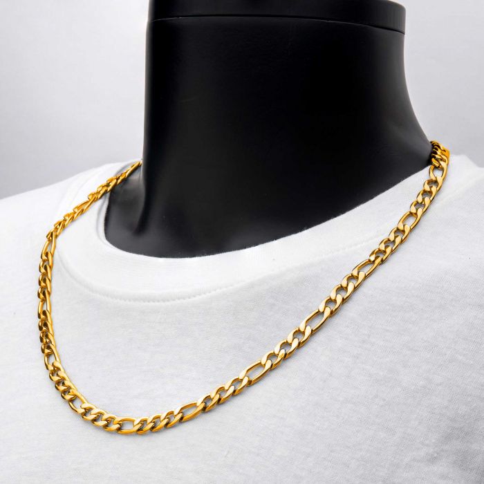 A close-up image of the 8mm 18K Gold Plated Figaro Chain by INOX, elegantly displayed on a black mannequin bust wearing a white t-shirt. The necklace, featuring interlocking links, lies neatly on the chest of the mannequin and measures 22 inches in length.