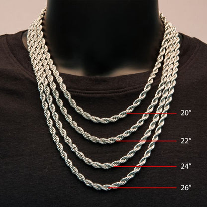 Close-up of a person wearing four 6mm Steel Rope Chains by INOX in varying lengths around their neck, displayed over a black shirt. The chains range from top to bottom: 20 inches, 22 inches (product name: 6mm Steel Rope Chain | 22" | INOX), 24 inches, and 26 inches, with markings indicating each length on the right side.