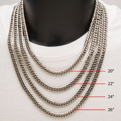 A close-up of a person wearing a white shirt and four men's necklaces made of 8mm steel dome curb chains from INOX. Each stainless steel necklace, including the 22" model known as the "8mm Steel Dome Curb Chain | 22" | INOX," ranges in length from 20" to 26". They are displayed hanging against a black background, showcasing their sleek design.