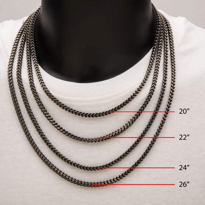 A display of four men's oxidized steel Franco chain necklaces by INOX on a black mannequin wearing a white shirt. Each 4mm Franco chain necklace varies in length: 20 inches, 22 inches, 24 inches, and 26 inches, from top to bottom, respectively.