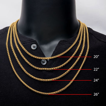 A black mannequin showcases five men's necklaces from the INOX brand, each an 18K gold plated wheat chain in lengths of 20 inches, 22 inches, 24 inches, and 26 inches. The gold chains beautifully contrast against the mannequin's black shirt with a buttoned neckline.