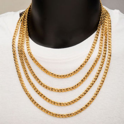 A close-up image of a person wearing an 18K gold plated classic curb chain by INOX around their neck. The 4mm, 24" chain creates a stunning cascading effect against a plain white shirt. The neutral background focuses attention on the elegant INOX gold jewelry.