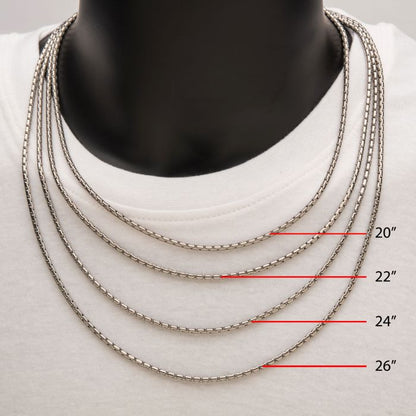 A photo of a mannequin adorned with four men's stainless steel Boston link chain necklaces, each varying in length: 20 inches, 22 inches, 24 inches (3mm Steel Boston Link Chain | INOX), and 26 inches. The necklaces are showcased on a white shirt with red text labels indicating their lengths next to each one.