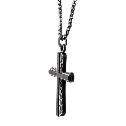 The Antique Gun Metal Sepulchre Genuine Ebony Wood Inlayed Cross Pendant on Chain by INOX features sleek, black metal craftsmanship complemented by a matching gun metal box chain necklace. The cross edges boast a subtle zigzag pattern, adding texture and dimension to its minimalist design. Set against a plain white background, this pendant truly stands out.